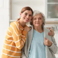 A female hugging a senior woman