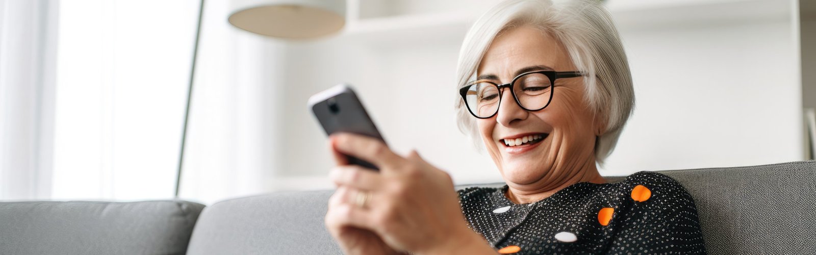 A senior woman smiling while looking at a mobile phone