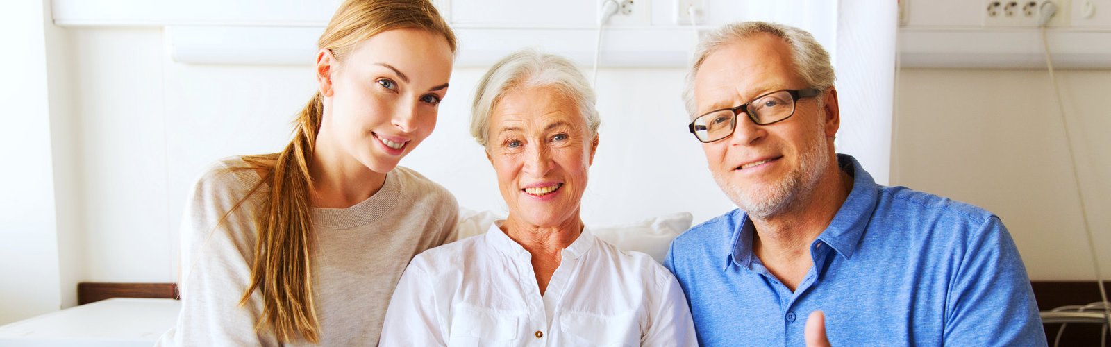 A senior couple and their daughter smiling together