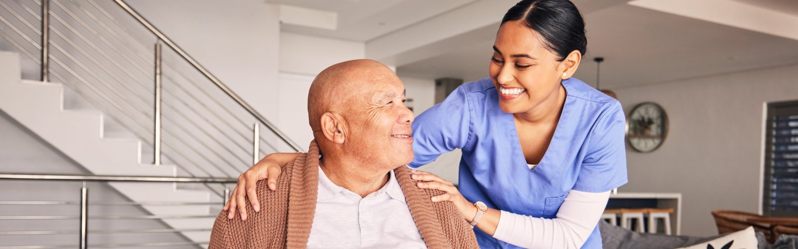 A female caregiver putting her hands on the shoulders of a senior man